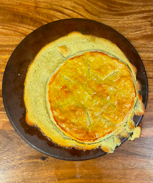 A round stoneware pan with a messy pastry disaster spilling across it and off the sides