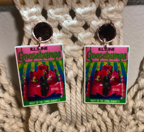 Image of two acrylic dangling earrings of Goosebumps book covers
