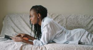 Image of a Black woman reading on a couch