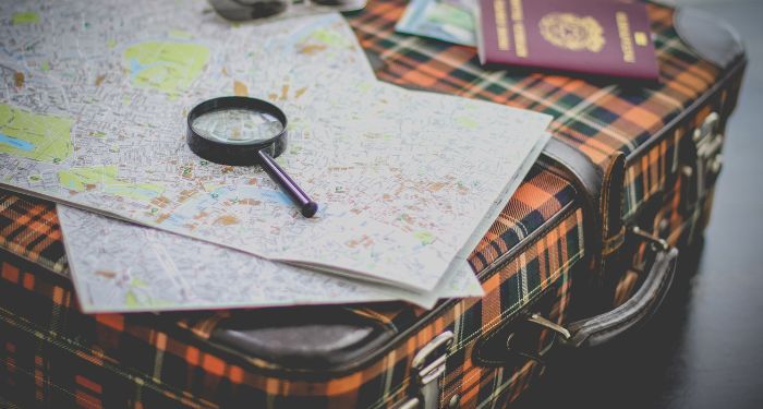 Image of a suitcase with magnifying glass and map