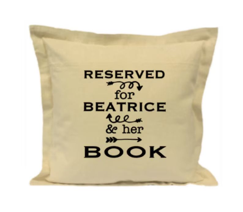 Photo of a beige pillow with the text reserved for Beatrice & her book.