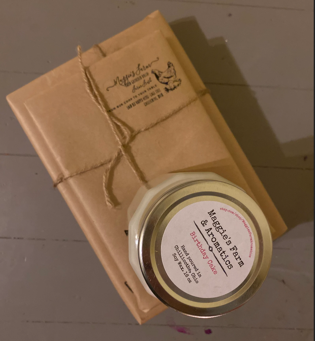 A book wrapped in brown paper and a soy wax candle in a jar