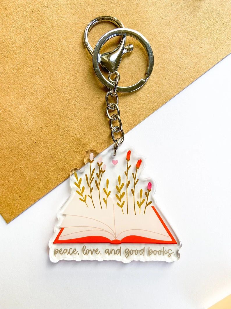 Photo of a keychain in the shape of an open book with flowers coming out of it.