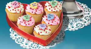a close up of Buttercream Bump-Off showing cupcakes with candy hearts saying "kiss me" "bite me" and "kill me"