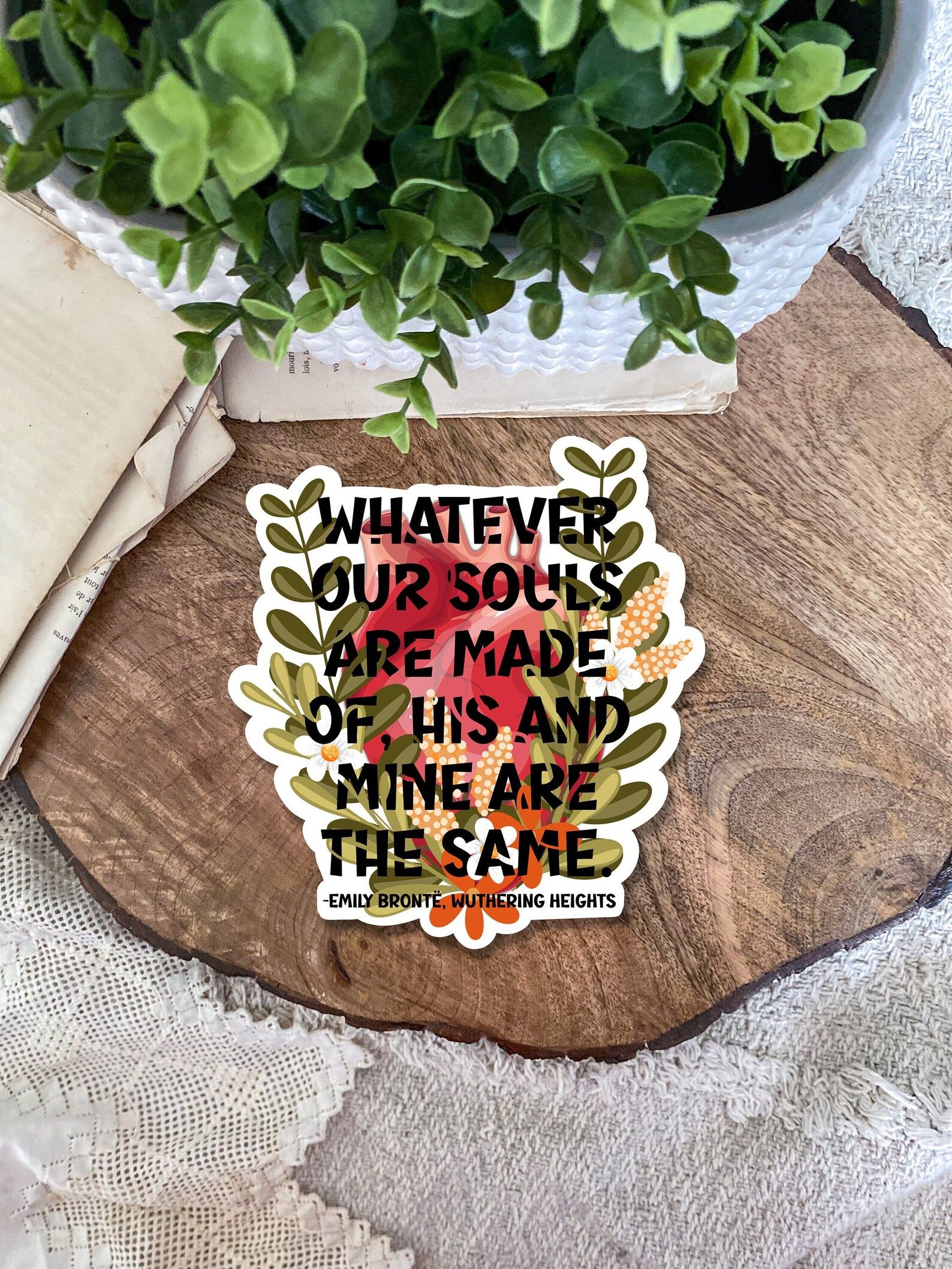 floral sticker with a quote from Emily Bronte's Wuthering Heights reading "Whatever our souls are made of, his and mine are the same."
