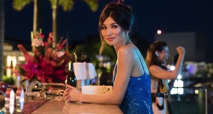 a still of Gemma Chan as Astrid in Crazy Rich Asians, showing her dressed up sitting at an outdoor bar