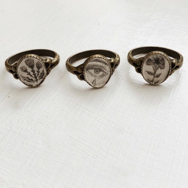 A set of Victorian-inspired rings from Etsy. Designs include flowers and a crying eye. 