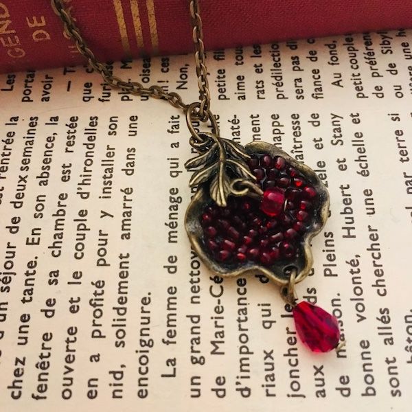 Bronze necklace with beading that looks like pomegranate seeds.