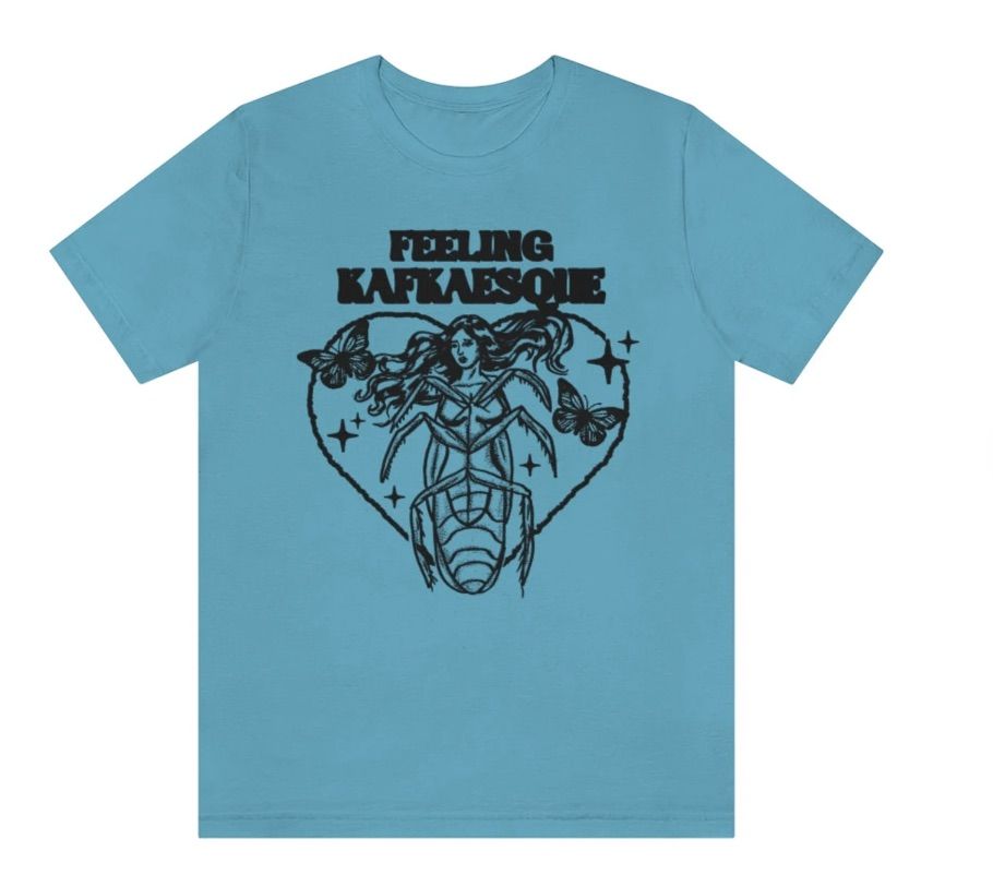 Image of a blue shirt. in the center is a half-human, half-bug creation with butterflies beside it. The text above reads "feeling Kafkaesque."