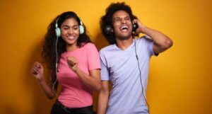 couple with brown skin listening to music on headphones