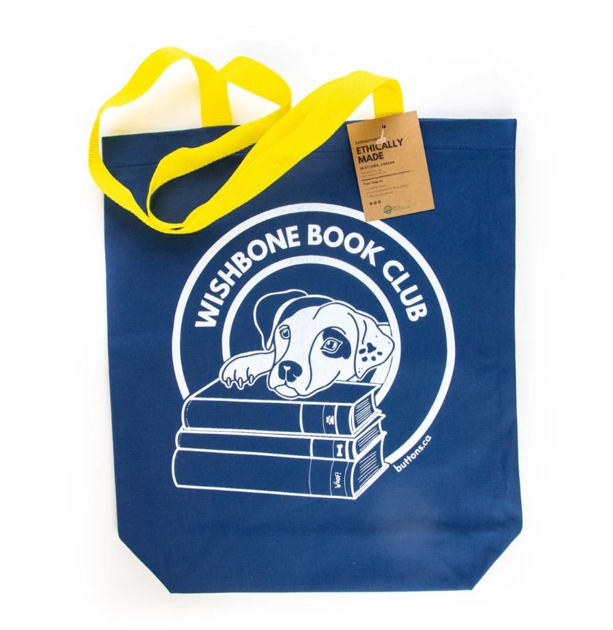 Image of a blue tote bag with Wishbone the dog and a pile of books. It says "wishbone book club."