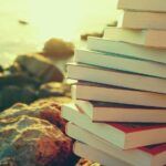 Image of stack of books on a rocky beach