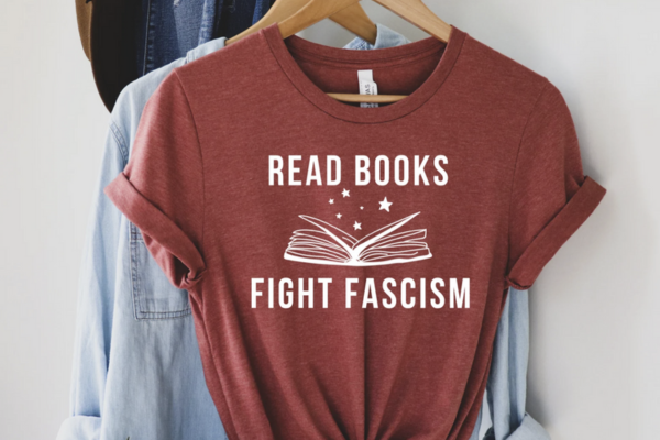 Red shirt featuring white text that says "read books. fight fascists" with an open book outline in between