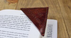 brown leather corner bookmark with embossed text that reads "to be continued"
