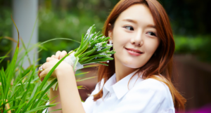 a photo of a Korean woman holding a bouquet of flowers, looking over her shoulder and smiling