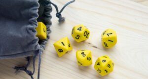 yellow table top game dice coming out of a gray pouch