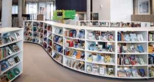 a photo of a library with curving white bookshelves