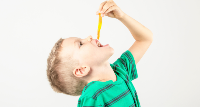 a photo of a kid eating a gummy worm