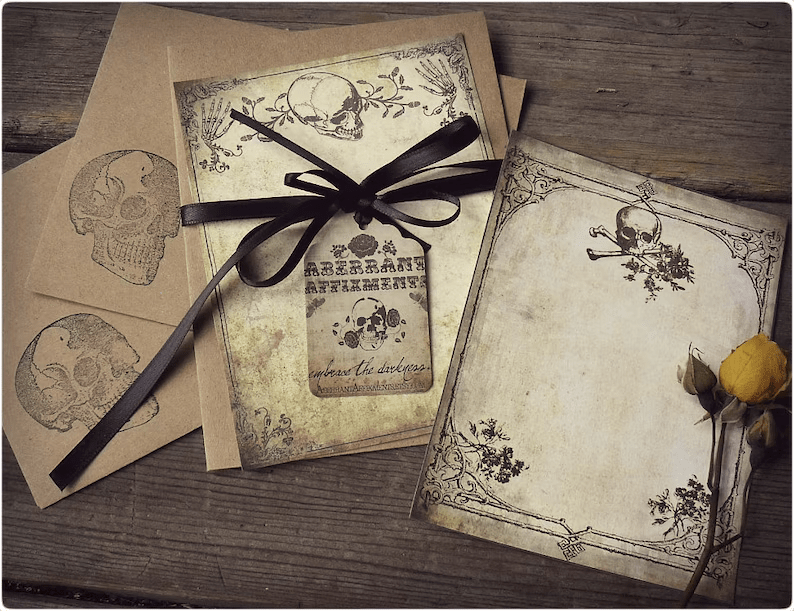 Photo of a writing set, the pages have skulls and flowers and plants on them. 