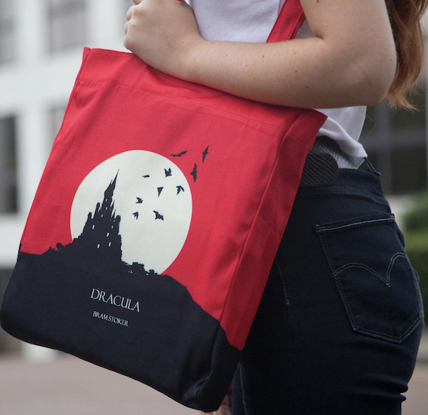 a red tote bag with a black castle and white moon that says Dracula