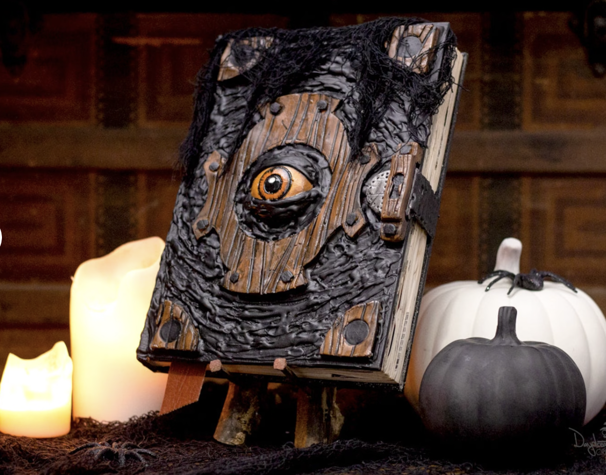 A fake wooden spell book with an eye in the center reminiscent of Hocus Pocus 