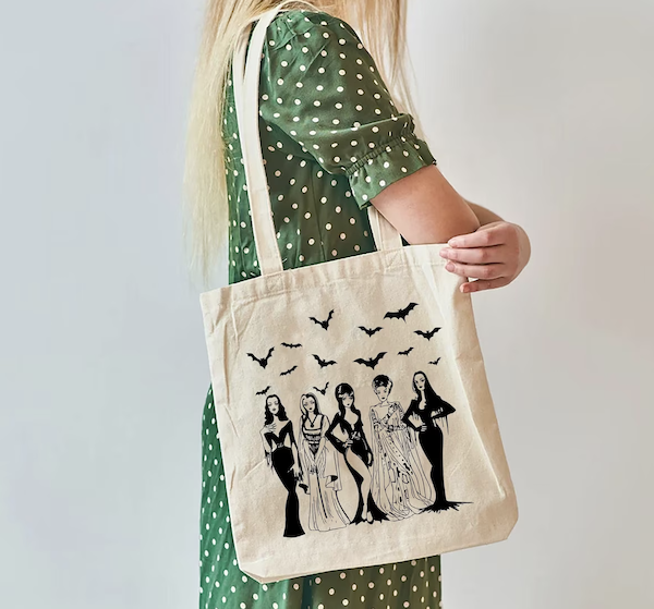 tote bag with graphic black screen print of women from horror including Elvira and Wednesday Addams
