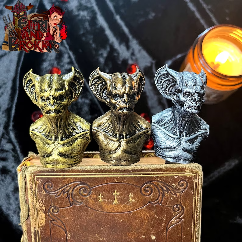 Photo of a leather book standing with three vampire figures made of resin peeking at the top. 