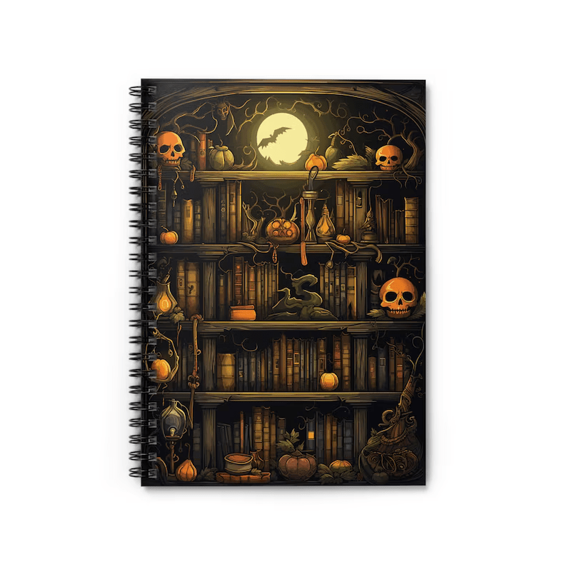 Photo of a notebook with spiral spine, the cover is a bookshelf filled with books with bats, pumpkins, skulls on the shelves, all with an orange hue. 