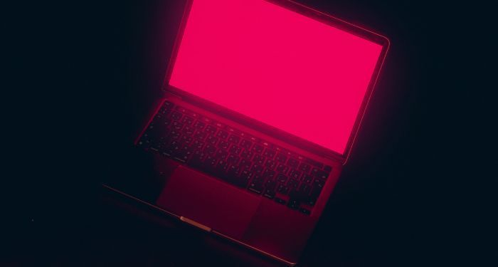 an open laptop emitting red neon light