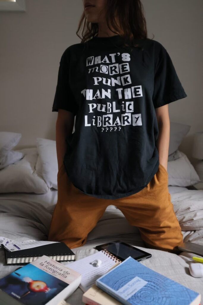 Black T-shirt with white lettering that reads "what's more punk than the public library?????"