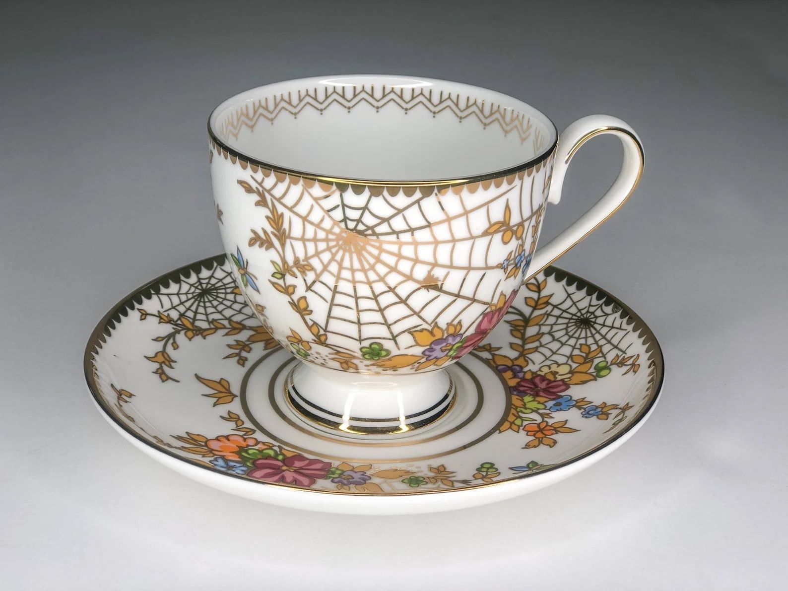 teacup with gold spiderweb pattern on it