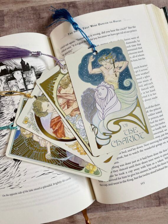 several tarot cards with an art nouveau style on top of a book