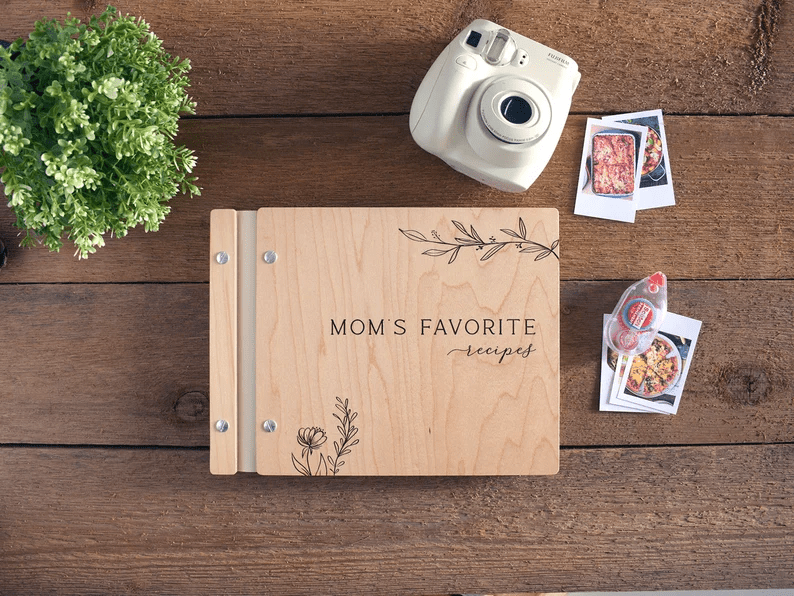 Photo of a wooden notebook with text and some flowers engraved on it