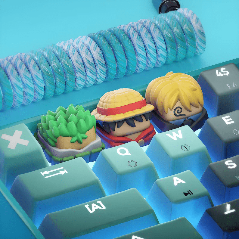 Photo of a leyboards with three keycaps shaped like One Piece characters.