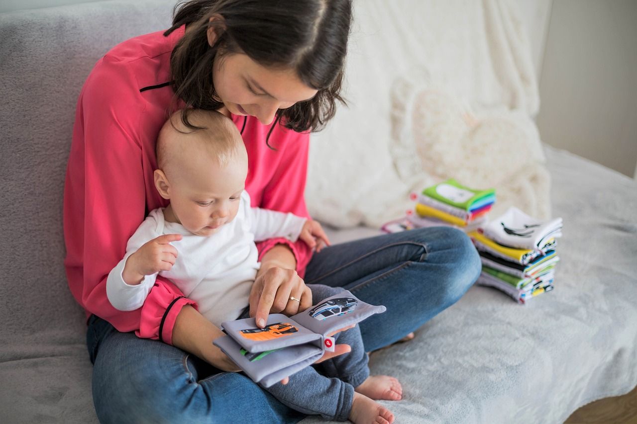 Image of a mother reading a soft book to a baby