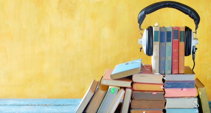 a stack of books with a pair of over-the-ear headphones over them