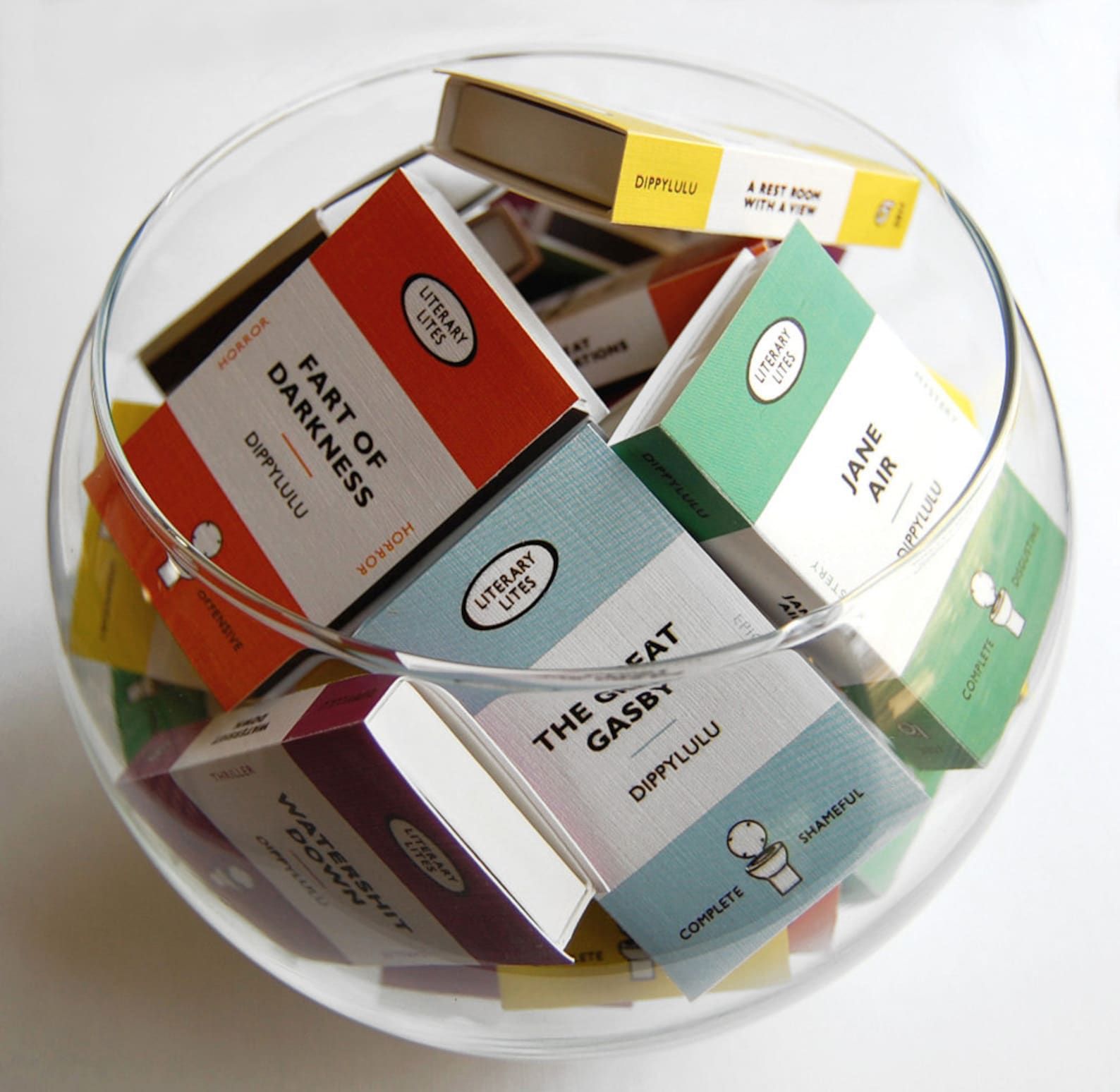 A glass bowl full of matchboxes in the design of Penguin Classics with gag titles