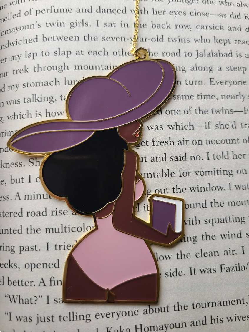 A metal bookmark of a brown-skinned Black woman with a large hat facing away