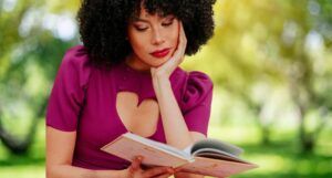 Black woman reading with magenta blouse