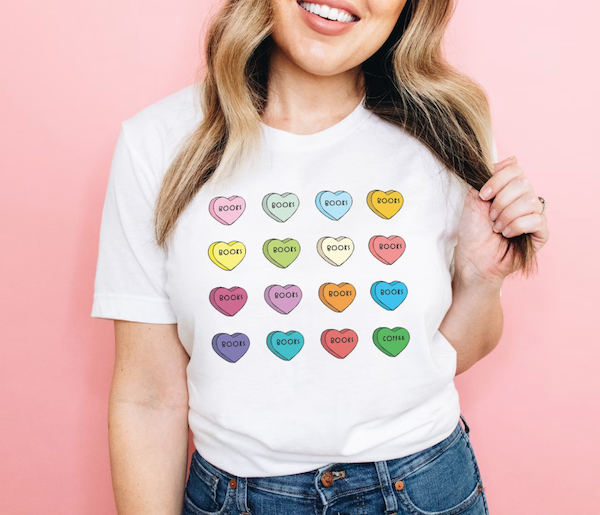A white t-shirt featuring multicolored conversation hearts that all say "BOOKS." 
