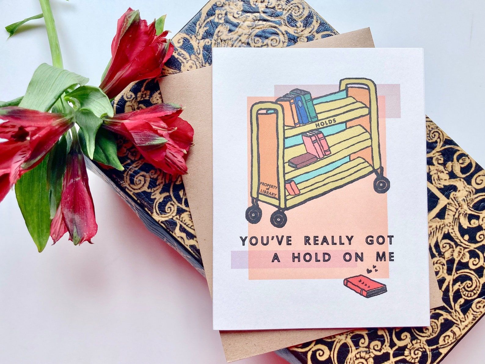A card depicting a library reserves cart with the words "You've really got a hold on me"