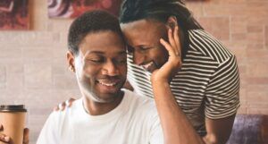 a cropped cover of Learned Reactions showing two Black men leaning their heads together and smiling