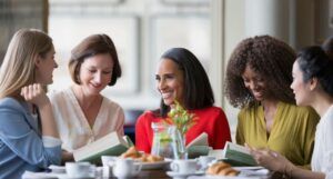 Black and white women eating, reading, and speaking with each other