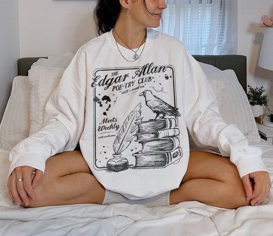 A white sweatshirt with an image of a bird perched on a stack of books and the words "Edgar Allen Poe-Try Club"