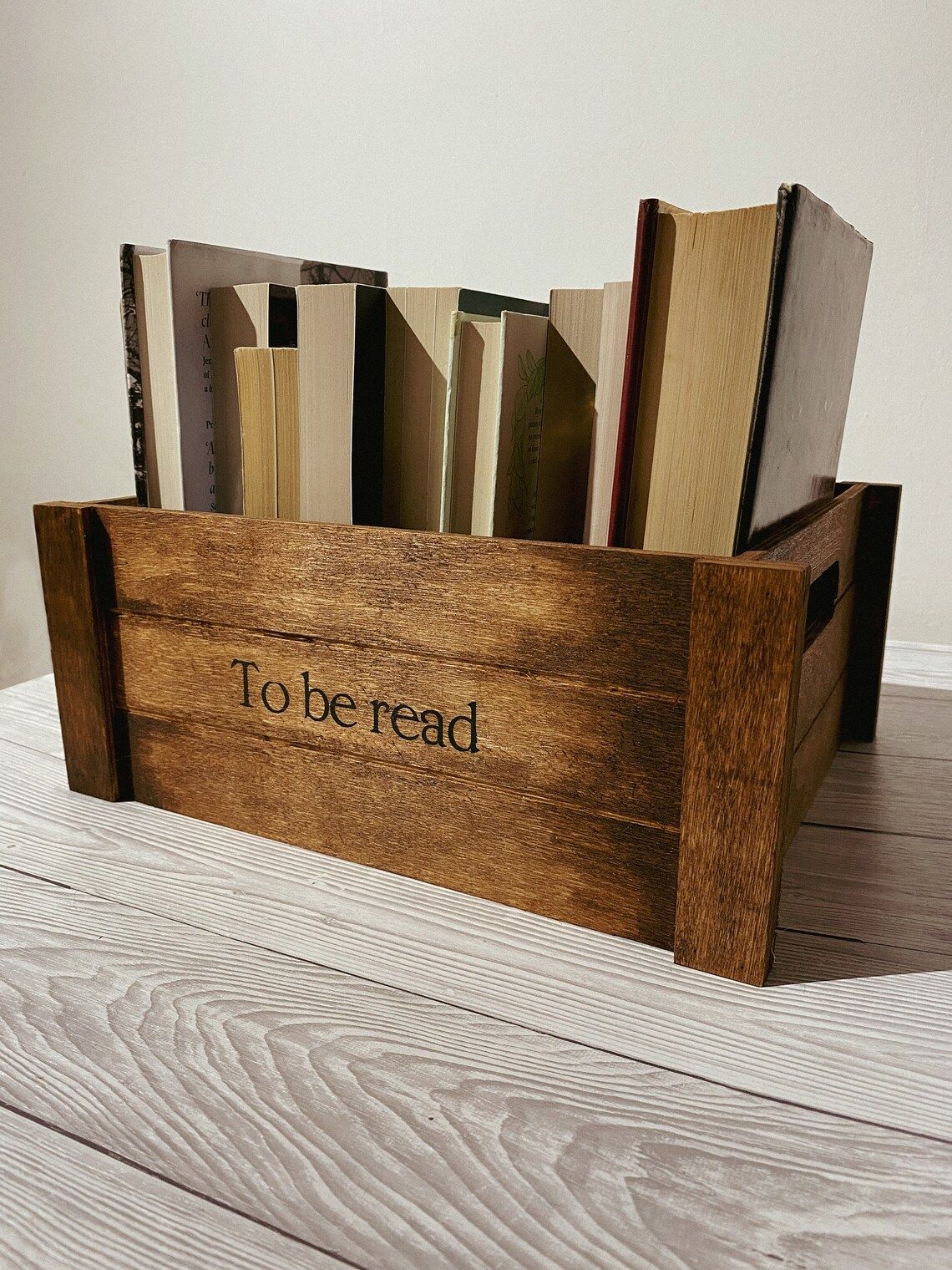 Wood crate containing books with "to be read" stenciled on the side