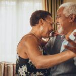Image of an elderly Black couple dancing in a living room