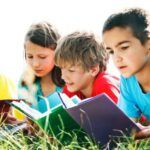 image of children reading in the grass