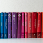a shelf of books in rainbow order