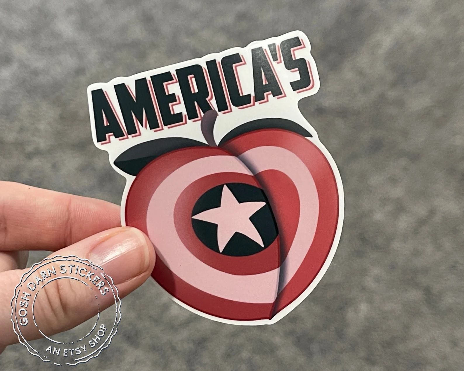 A sticker of a peach-shaped Captain America shield with the word "America's" written in capital letters above