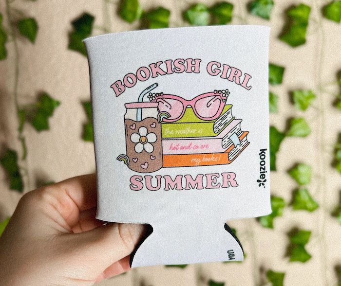 drink cozy with image of books, sunglasses, and drink on it